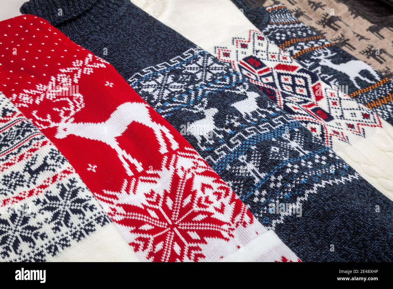 Various warm seasonal Christmas jumpers aka Ugly sweaters with deer and snowflake ornament laid folded Stock Photo
