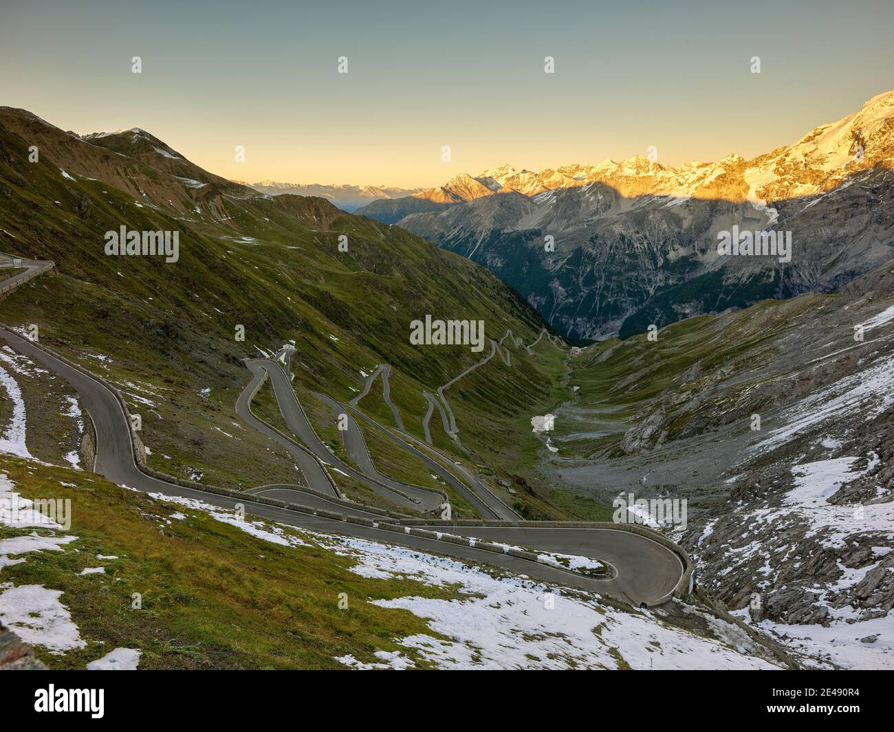 Pass road, pass road, alpine pastures, rocks, peaks, glaciers, snow, onset of winter, blue sky, cloudless, rugged, wild, evening mood, evening light, autumn, late summer, September, curves, serpentines Stock Photo