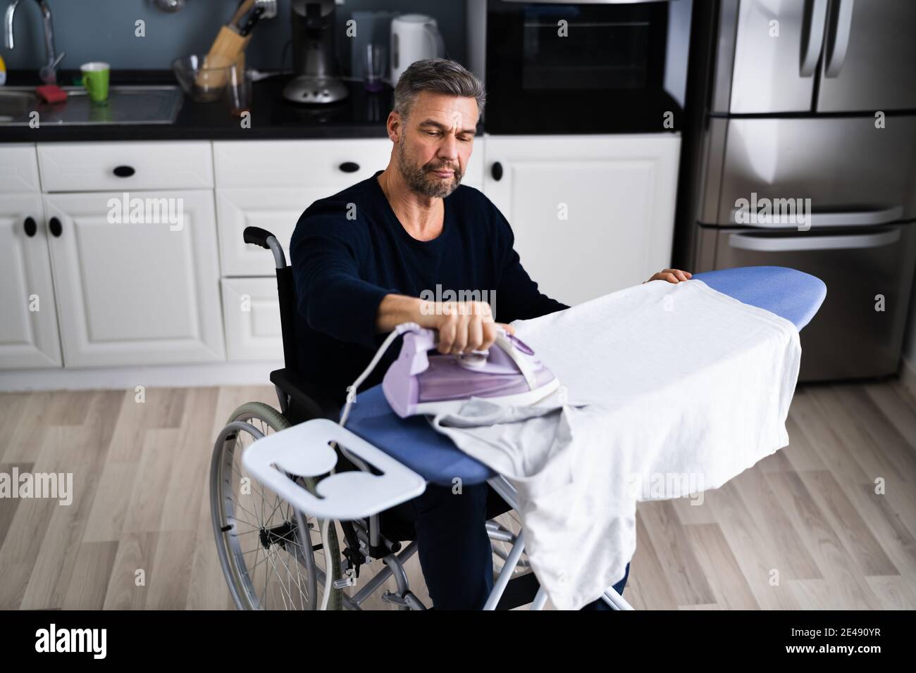 Handicapped Disabled Man In Wheelchair Ironing Clothes Stock Photo Alamy