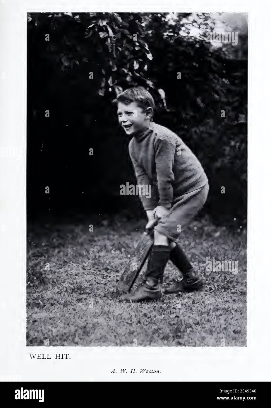 Vintage 1916 photograph of a young boy with bat in hand playing cricket in the garden Stock Photo