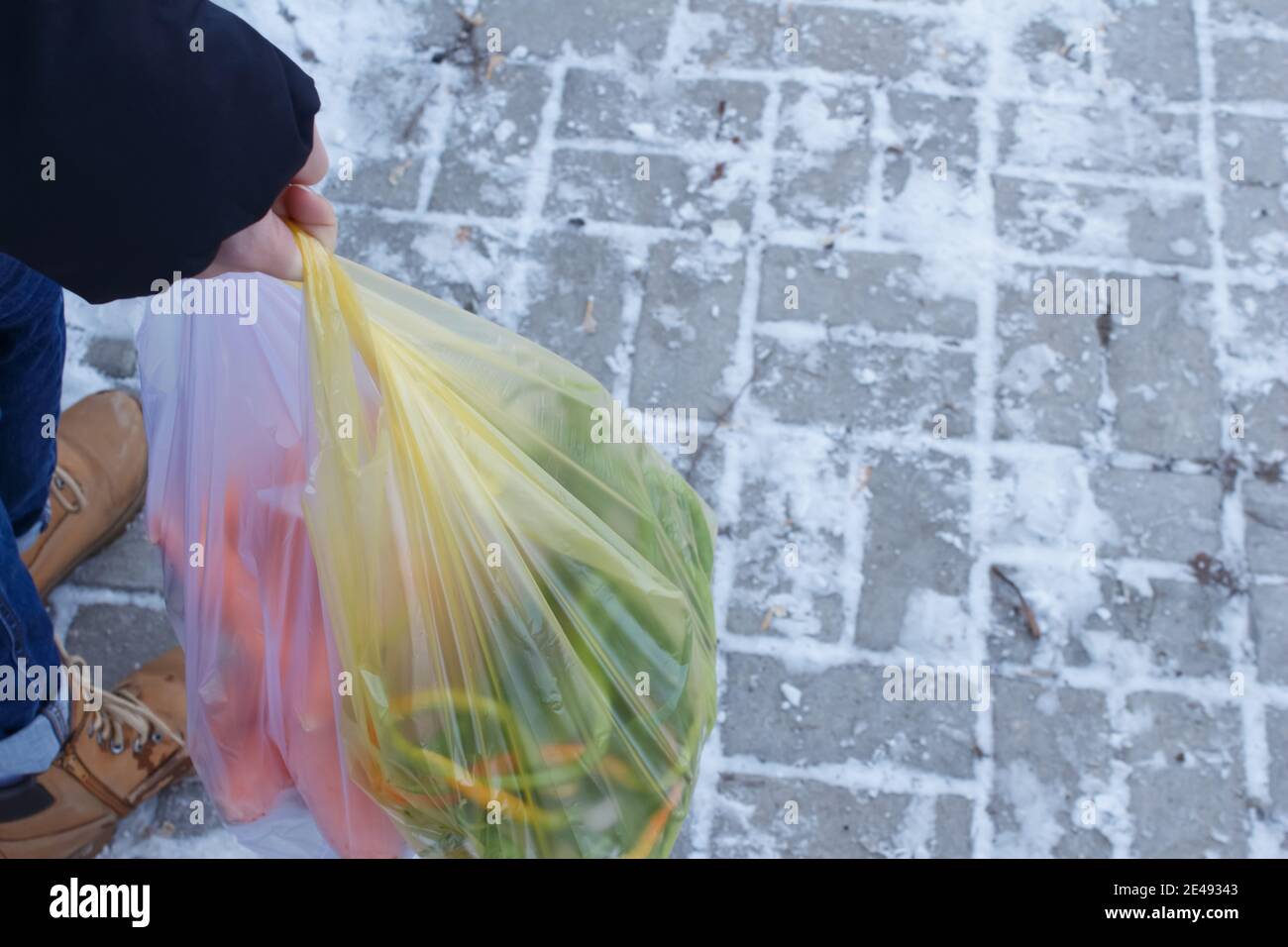 Closeup of woman's hand carrying plastic grocery shopping bag. The