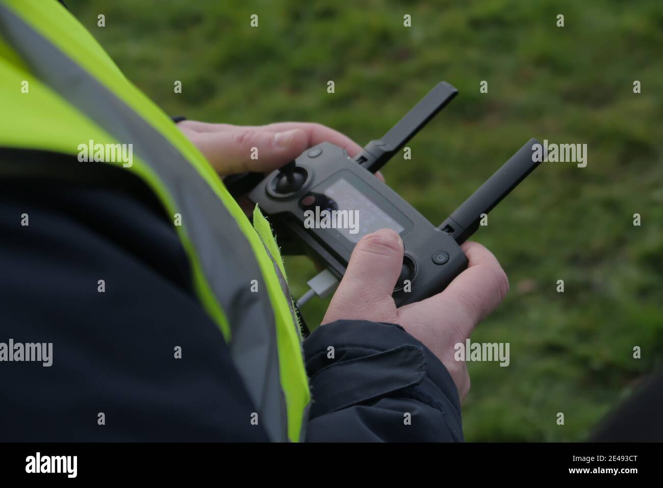 Selective focus shot of a drone pilot flying a drone using a remote control Stock Photo