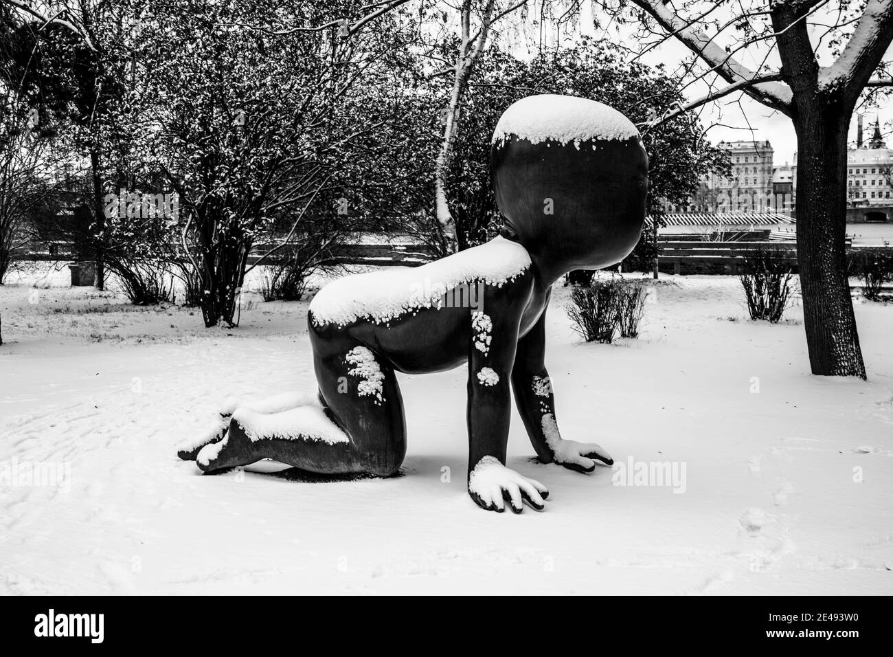 PRAGUE, CZECH REPUBLIC - JANUARY 14, 2021: Babies - Bronze scupltures installed on Kampa Island in Prague, Czech Republic. Artist: David Cerny. Sculptures covered by snow in winter. Black and white image. Stock Photo