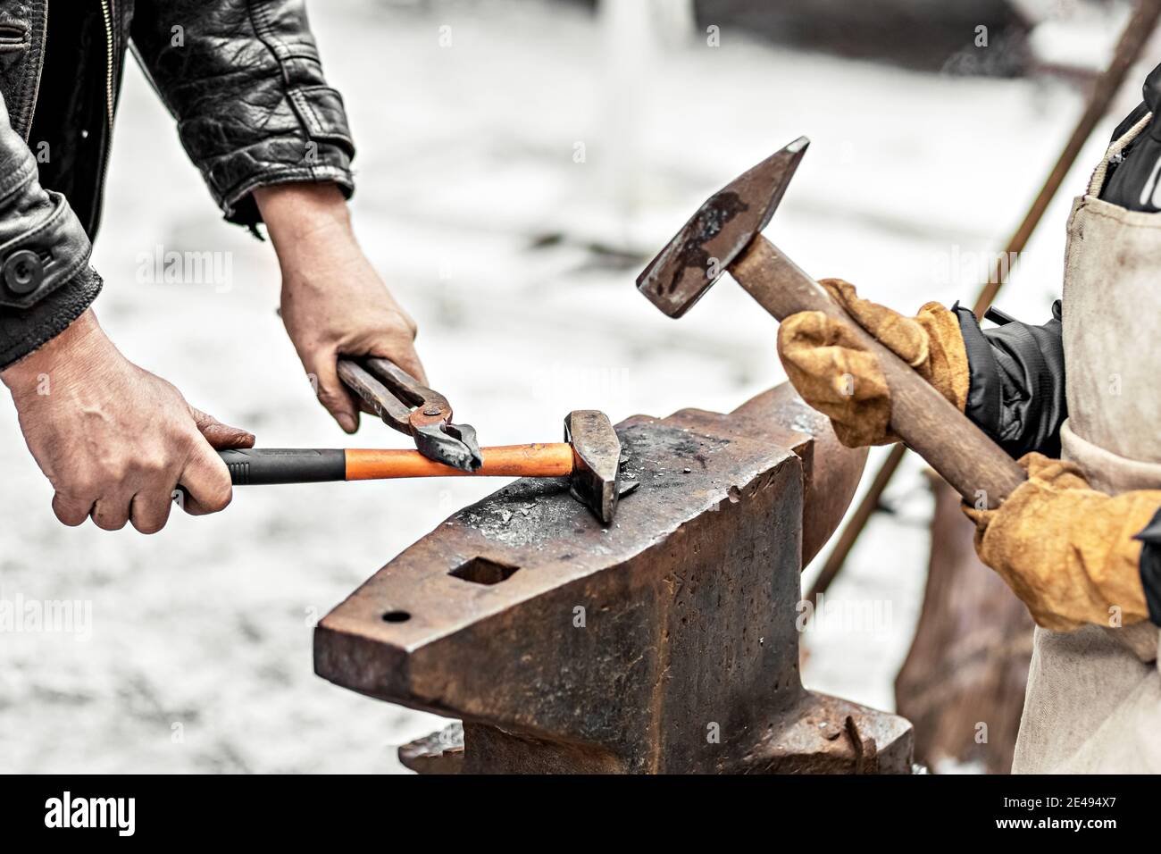 A blacksmith man and his son forge a horseshoe on an anvil Stock Photo ...
