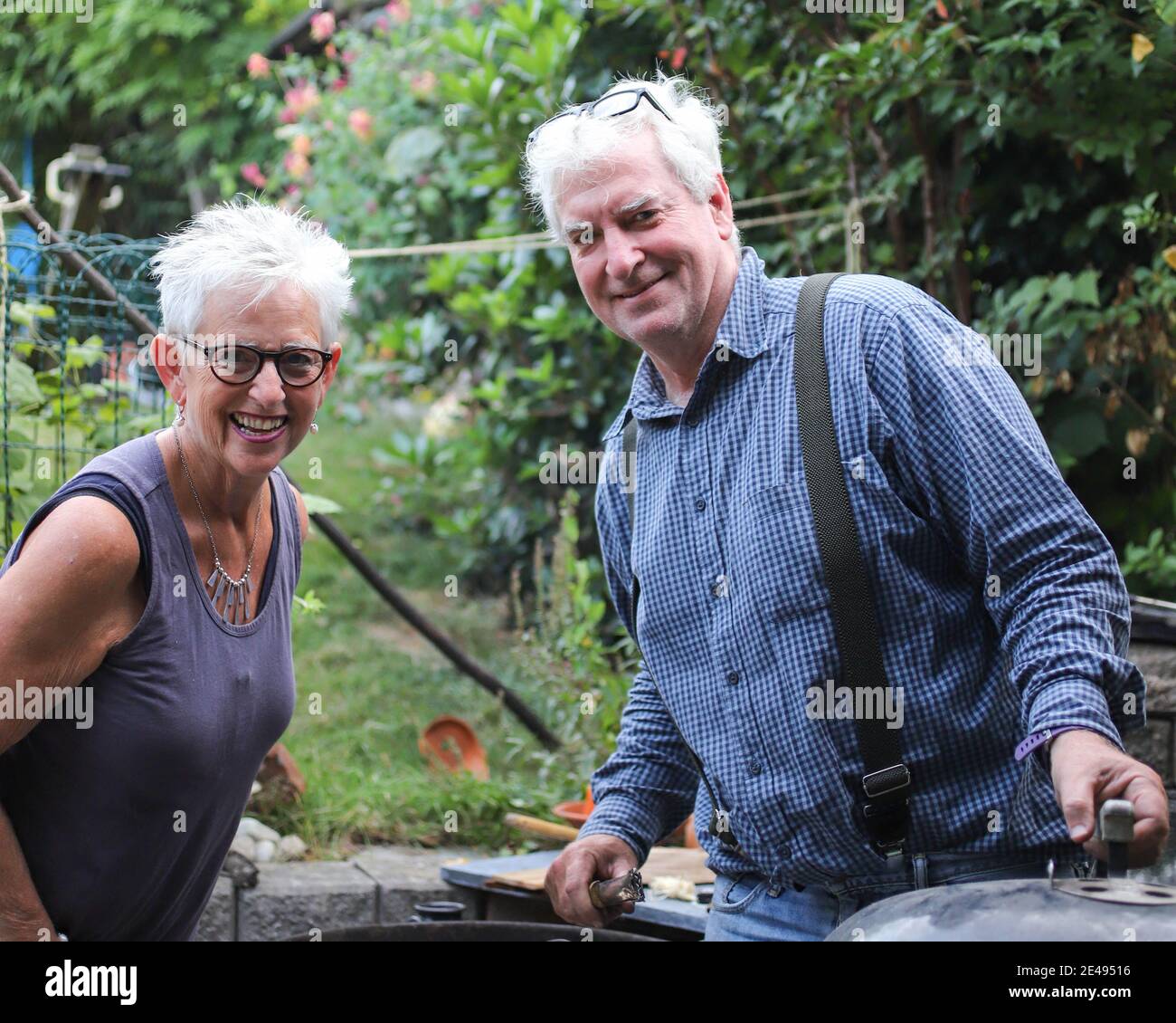 Two white haired, bespectacled brother and sister in a Belgium garden Stock Photo