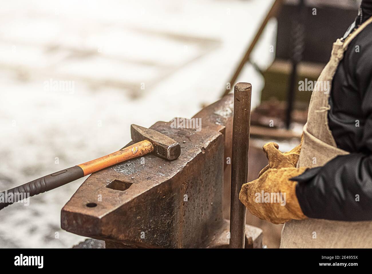 The boy, the blacksmith's son, stands at the anvil. The process of forging. Stock Photo