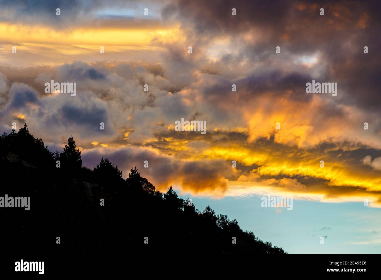 Fiery sunset and clouds over hillside at Oamaru, South Island, New Zealand. Stock Photo