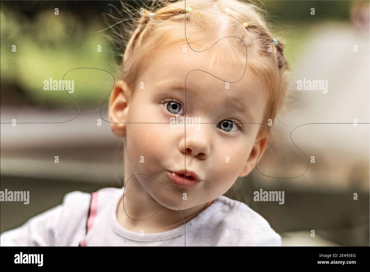 Portrait of a small surprised girl close-up in the form of puzzles. Emotions Stock Photo