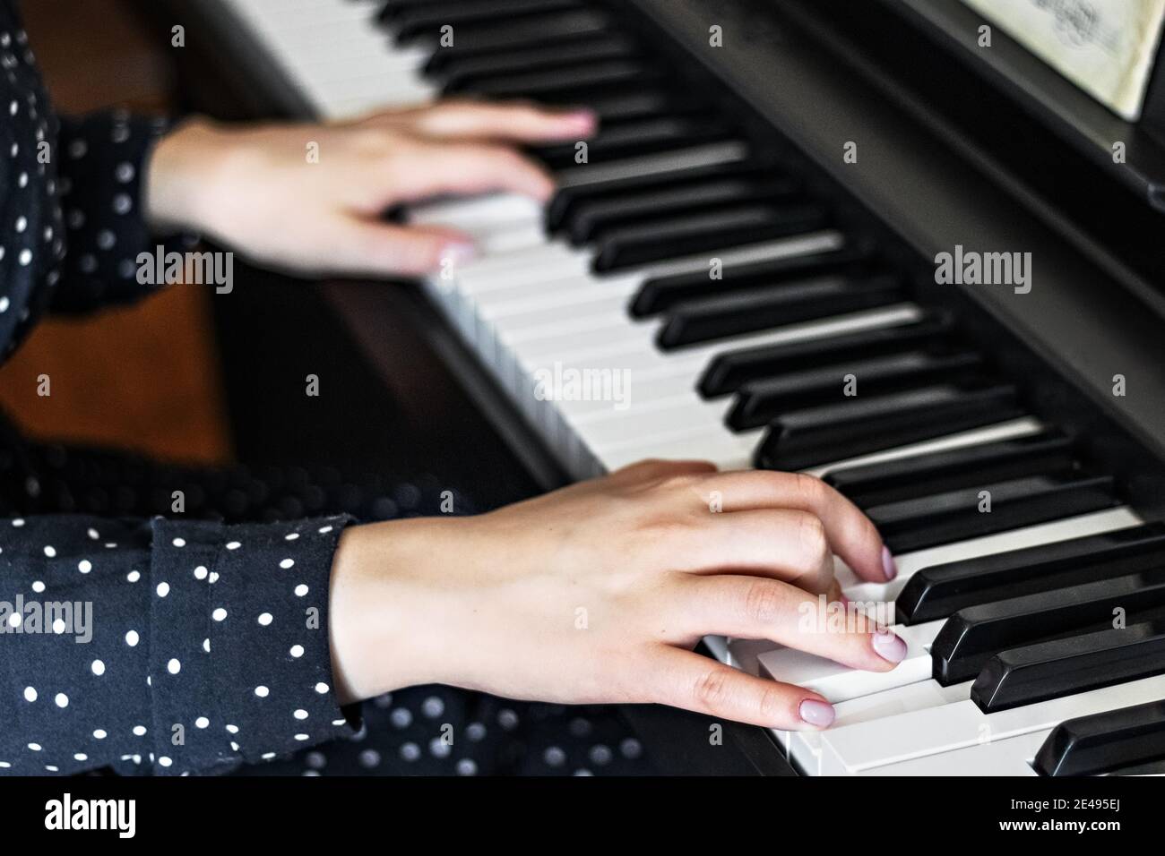 Hands of a young girl pianist on the keys of a synthesizer. Stock Photo
