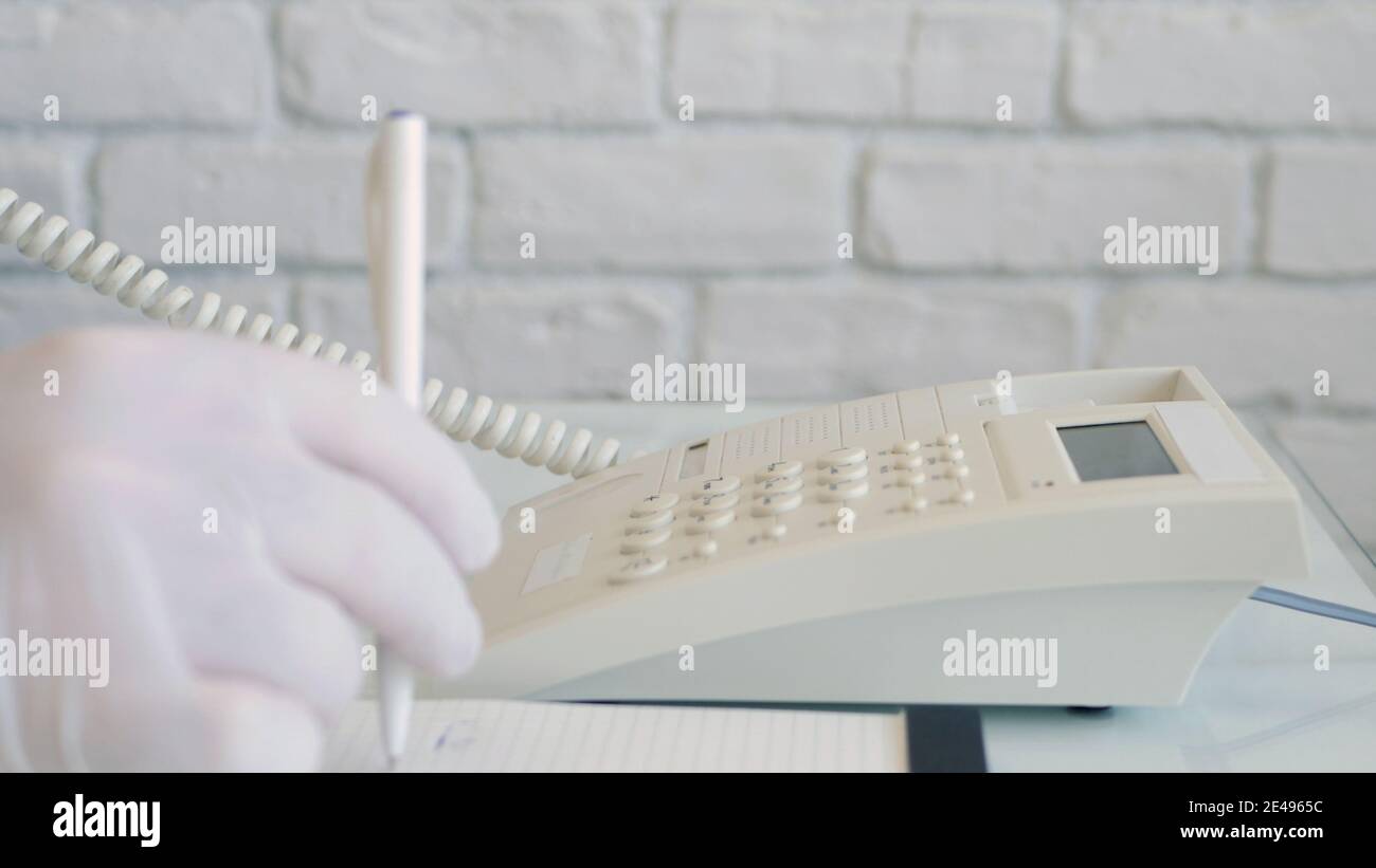 Man Wearing Protection Gloves in Hands Using Telephone Communication. Social Distancing Lifestyle Stock Photo