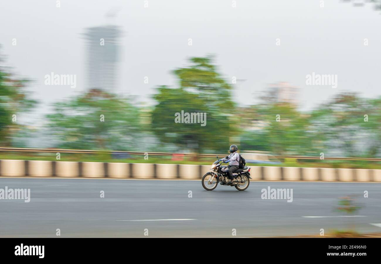 MUMBAI, INDIA - December 17, 2020 : Unidentified motorcyclist driving a two-wheel motorbike on streets of Mumbai Stock Photo