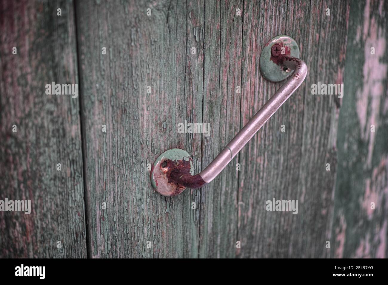 An old rusty doorknob on a wooden door. Close up. Stock Photo