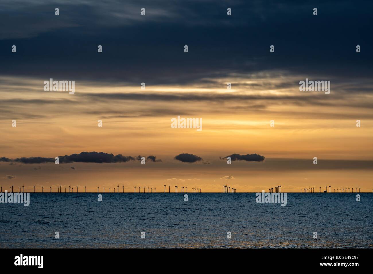 Renewable energy off the coast at dusk Stock Photo