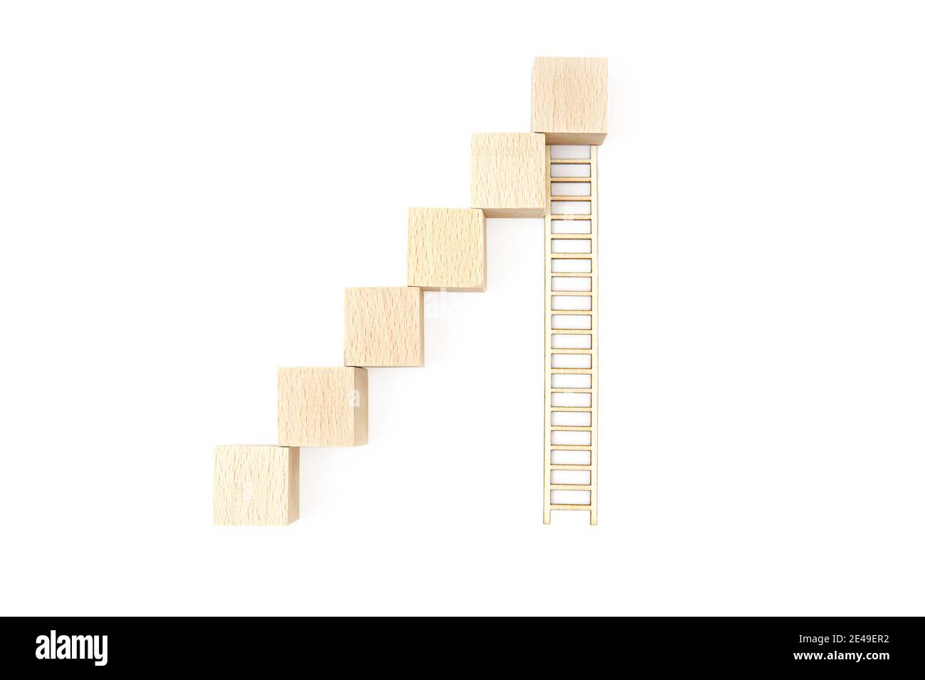Staircase made of toy wooden blocks and a long wooden ladder isolated on white background. Career building concept. Stock Photo