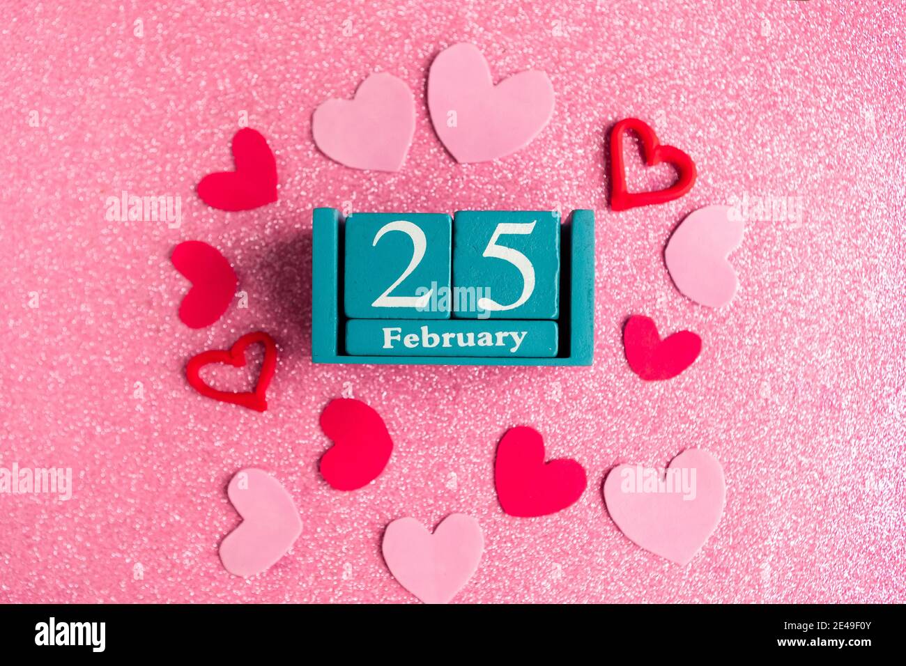 February 25. Blue cube calendar with month and date and decorations on ...