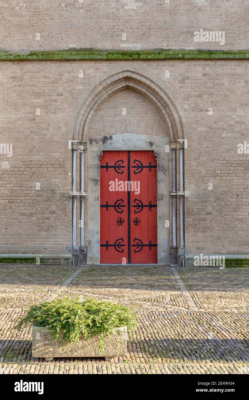 Background with ancient brown red door in brick wall Stock Photo