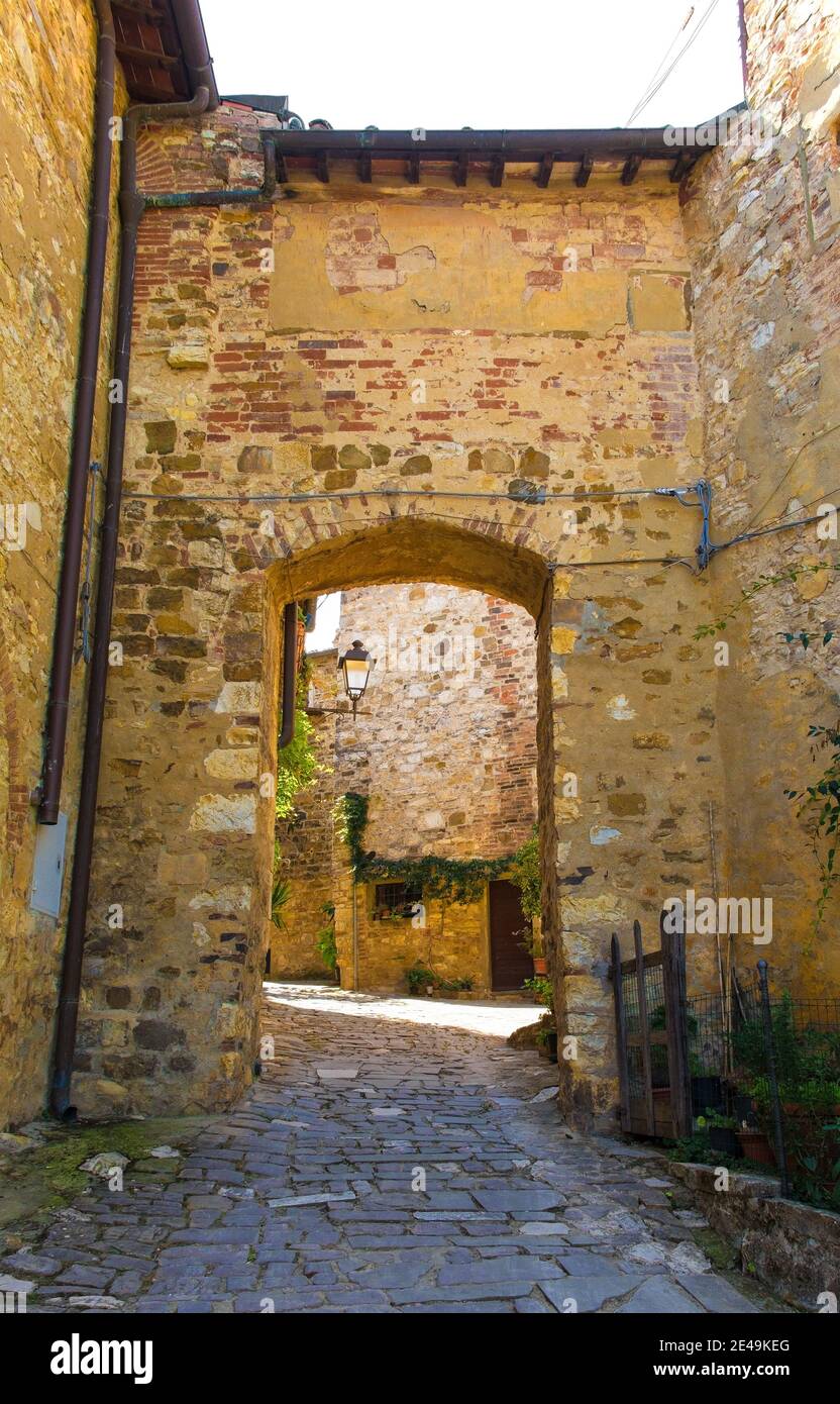 A stone archway across a quiet residential street in the historic medieval village of Montefioralle near Greve in Chianti in Florence province, Tuscan Stock Photo