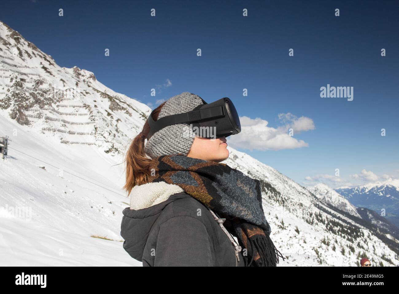 Person mit Virtual-Reality-Brille vor Bergkulisse Stock Photo