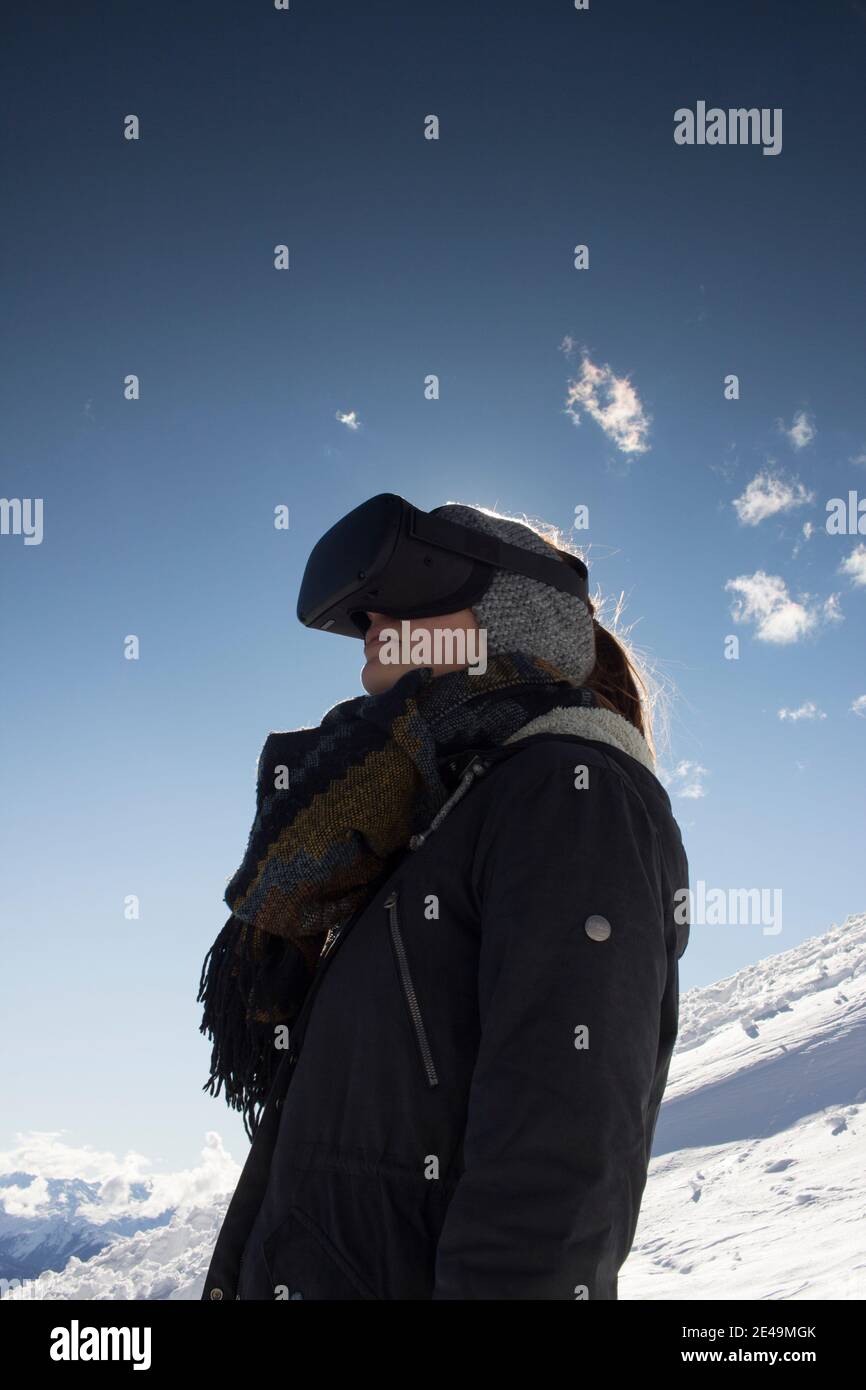 Person mit Virtual-Reality-Brille vor Bergkulisse Stock Photo