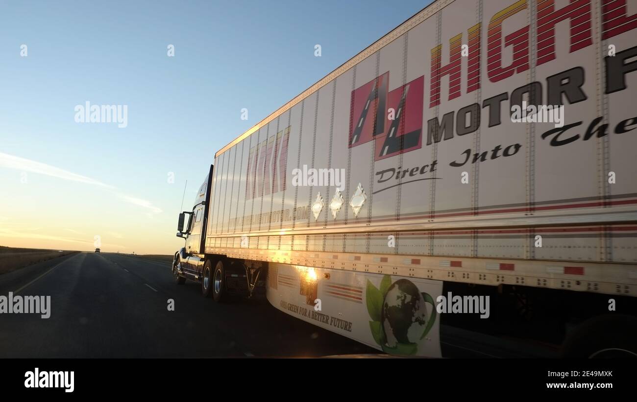 Semi truck rolling down toward the sunset on Interstate 80, Indiana Stock Photo