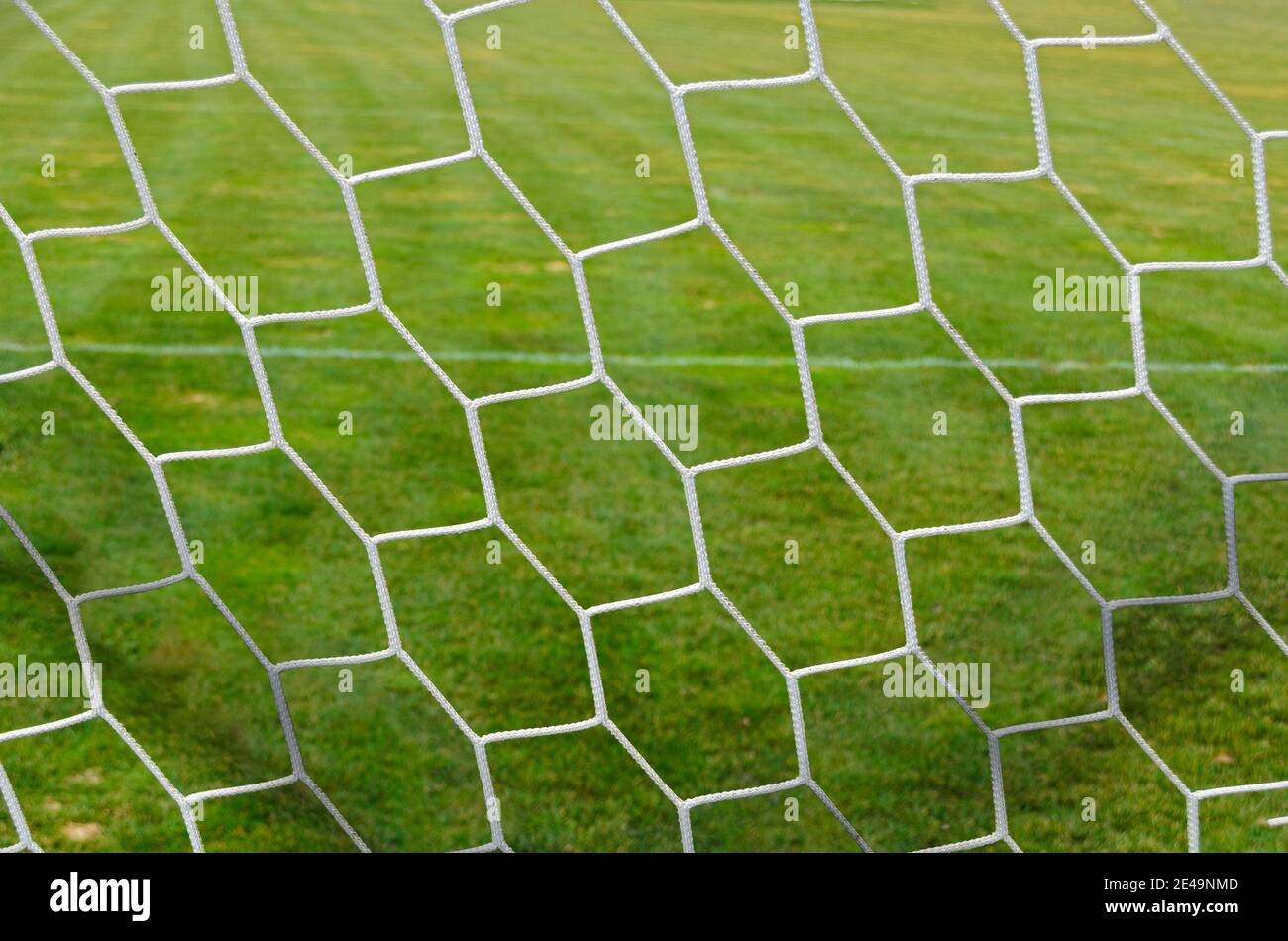 view through the net of a soccer goal with isohedral pattern onto the play ground Stock Photo