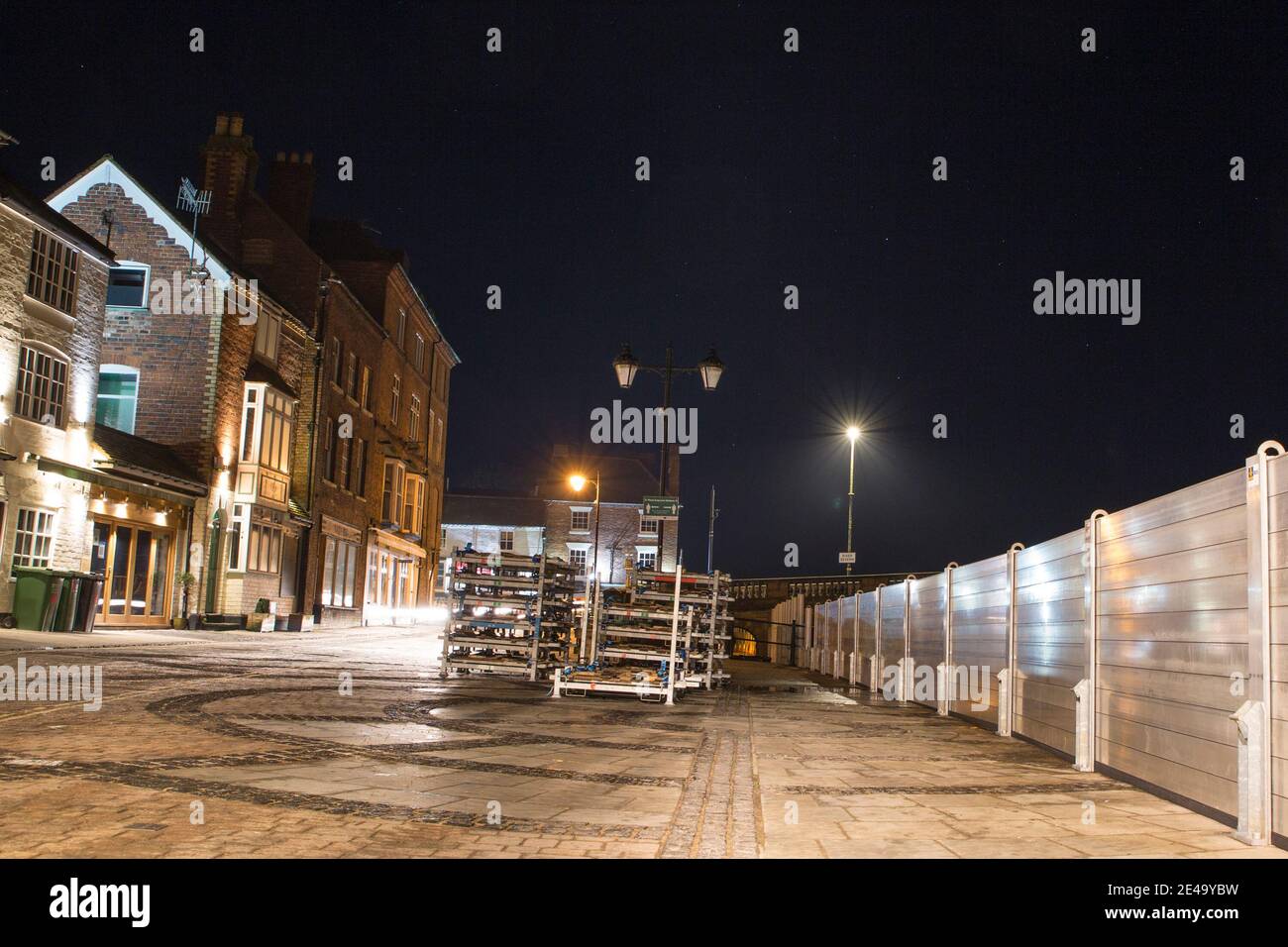 Flood barriers installed in Bewdley beacause of storm Christoph. A photograph taken at night with property fronts lit up along the river front. Stock Photo