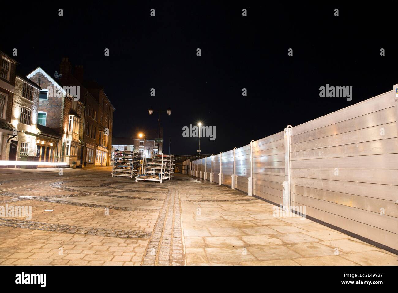 Flood barriers installed in Bewdley beacause of storm Christoph. A photograph taken at night with property fronts lit up along the river front. Stock Photo