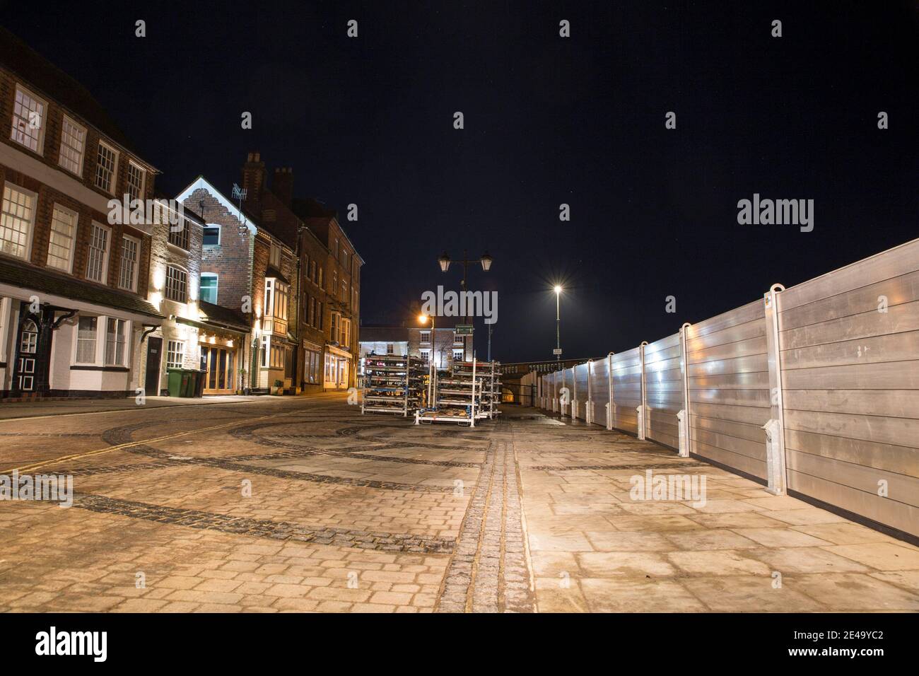 Flood barriers installed in Bewdley beacause of storm Christoph. A photograph taken at night with property fronts lit up along the river front. Stock Photo