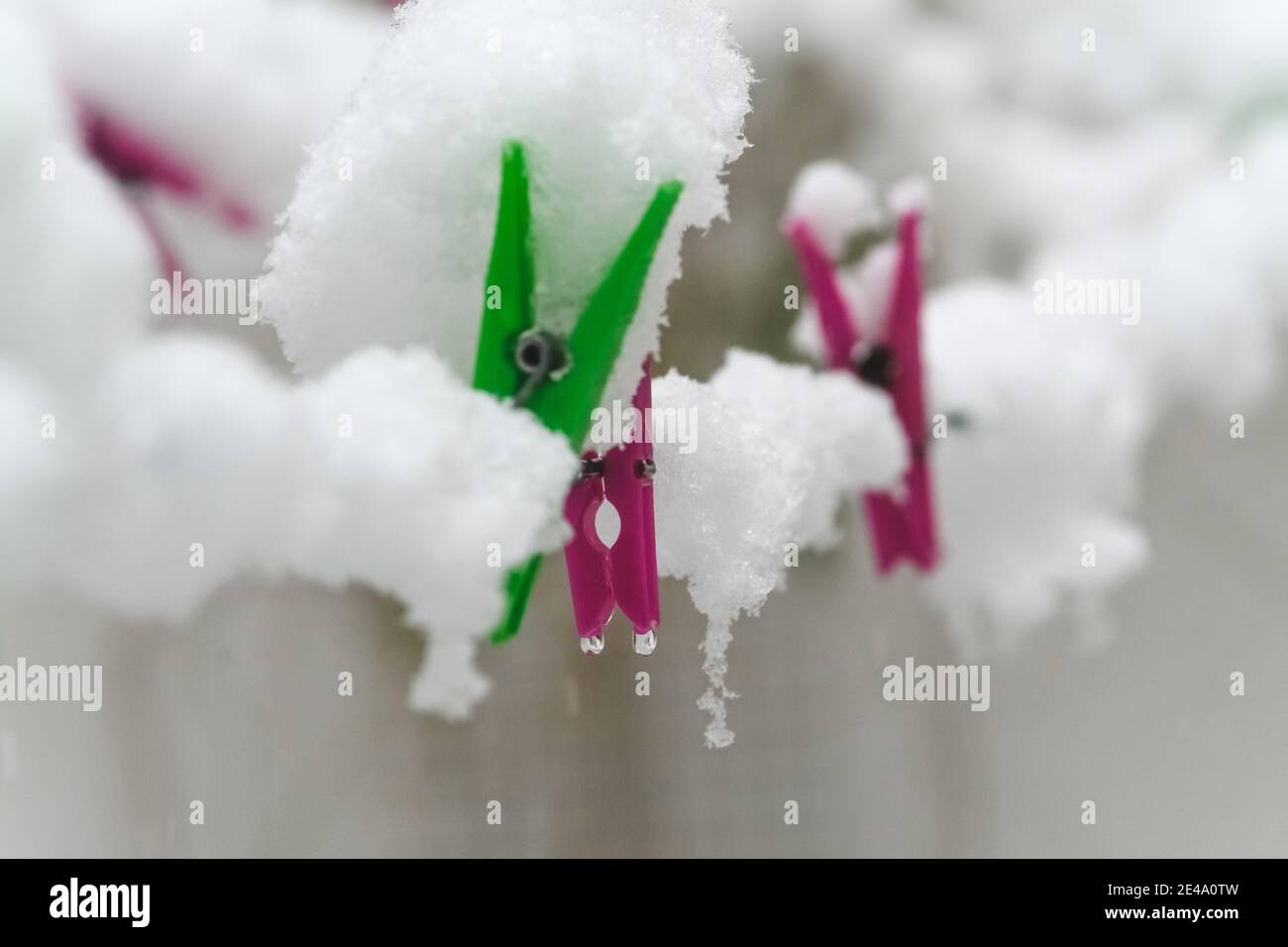 macro photography of clothespins on a clothesline covered by snow that has fallen in winter Stock Photo