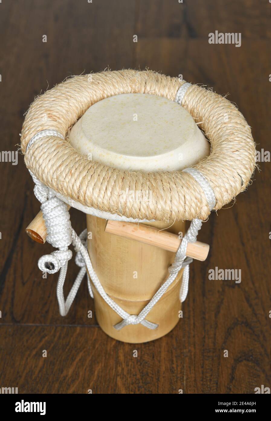 Bamboo bongo drum with tightened animal skin on dark wood Stock Photo