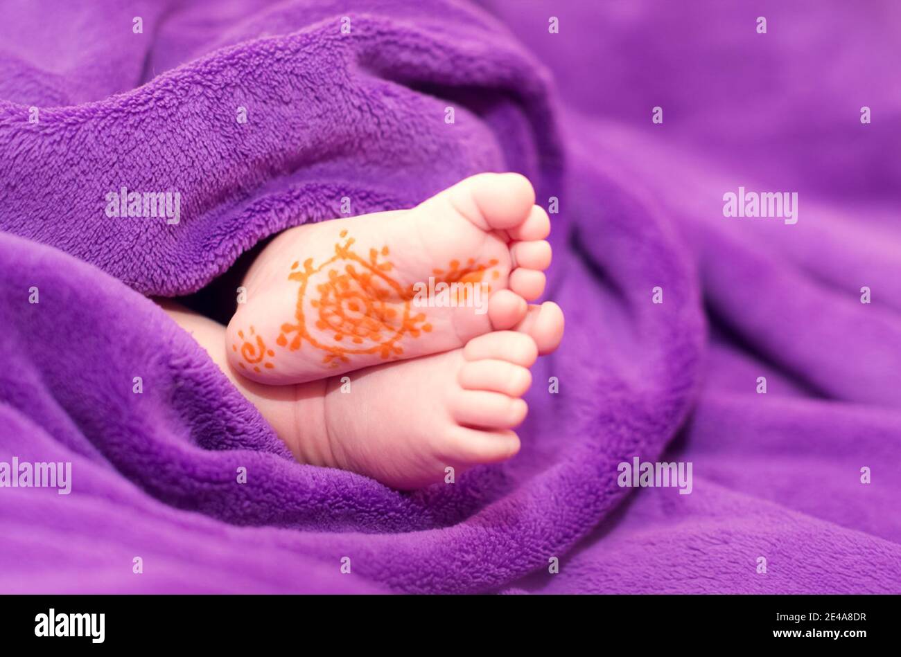 The baby's legs are from under the blanket. On the leg painted a