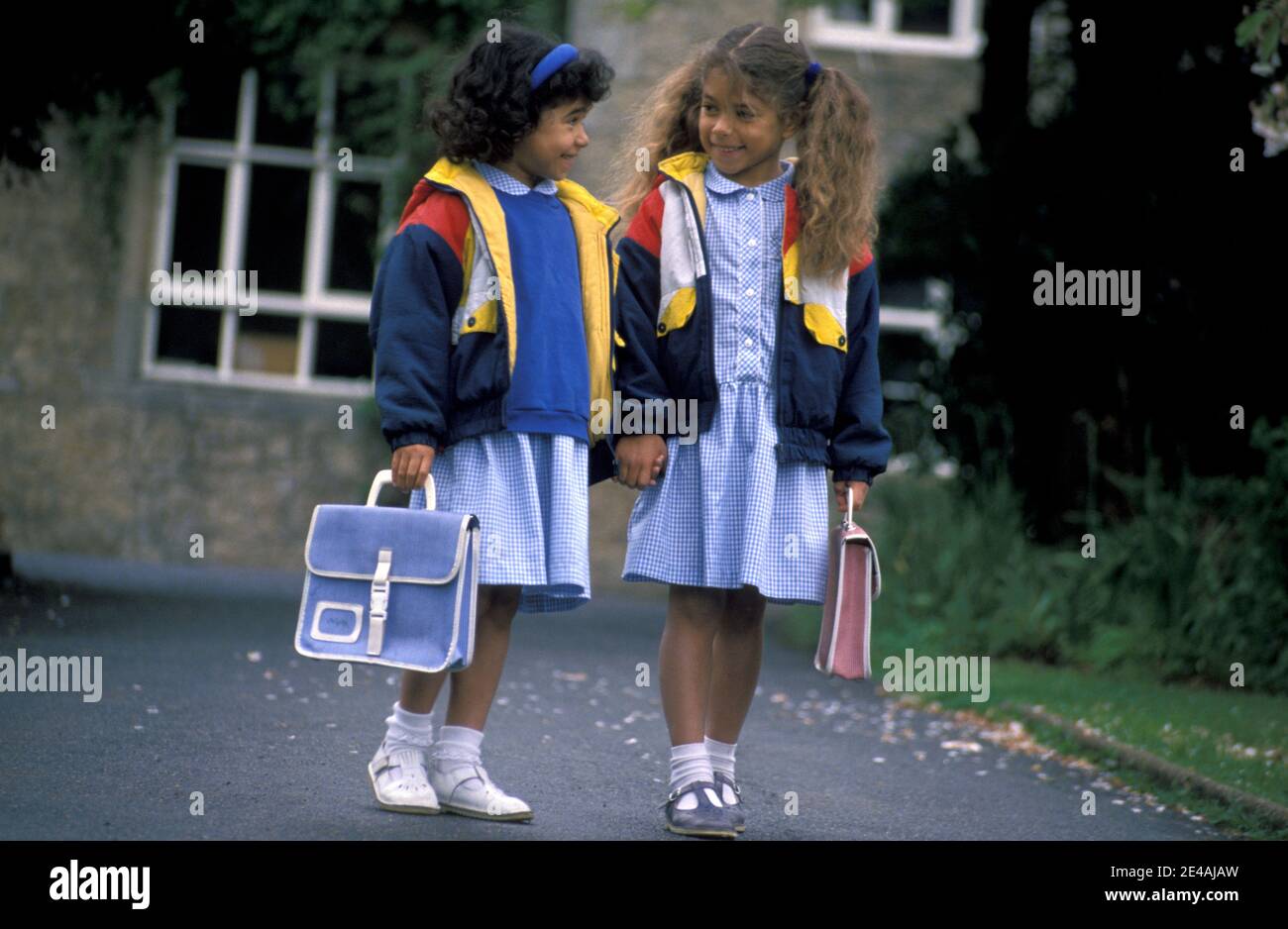 two young girls walking out of primary school Stock Photo
