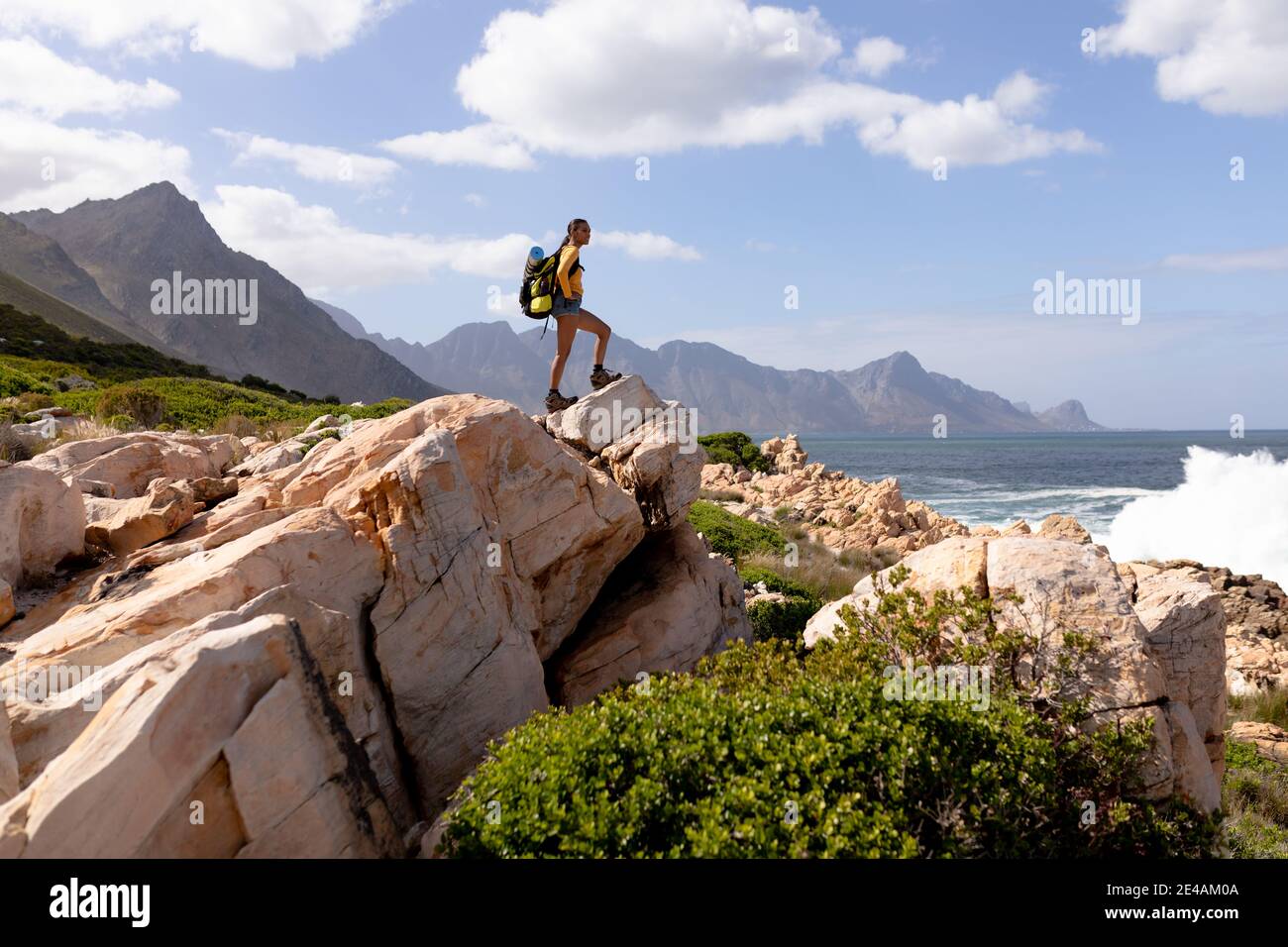 Fit afrcan american woman wearing backpack hiking on the coast Stock Photo