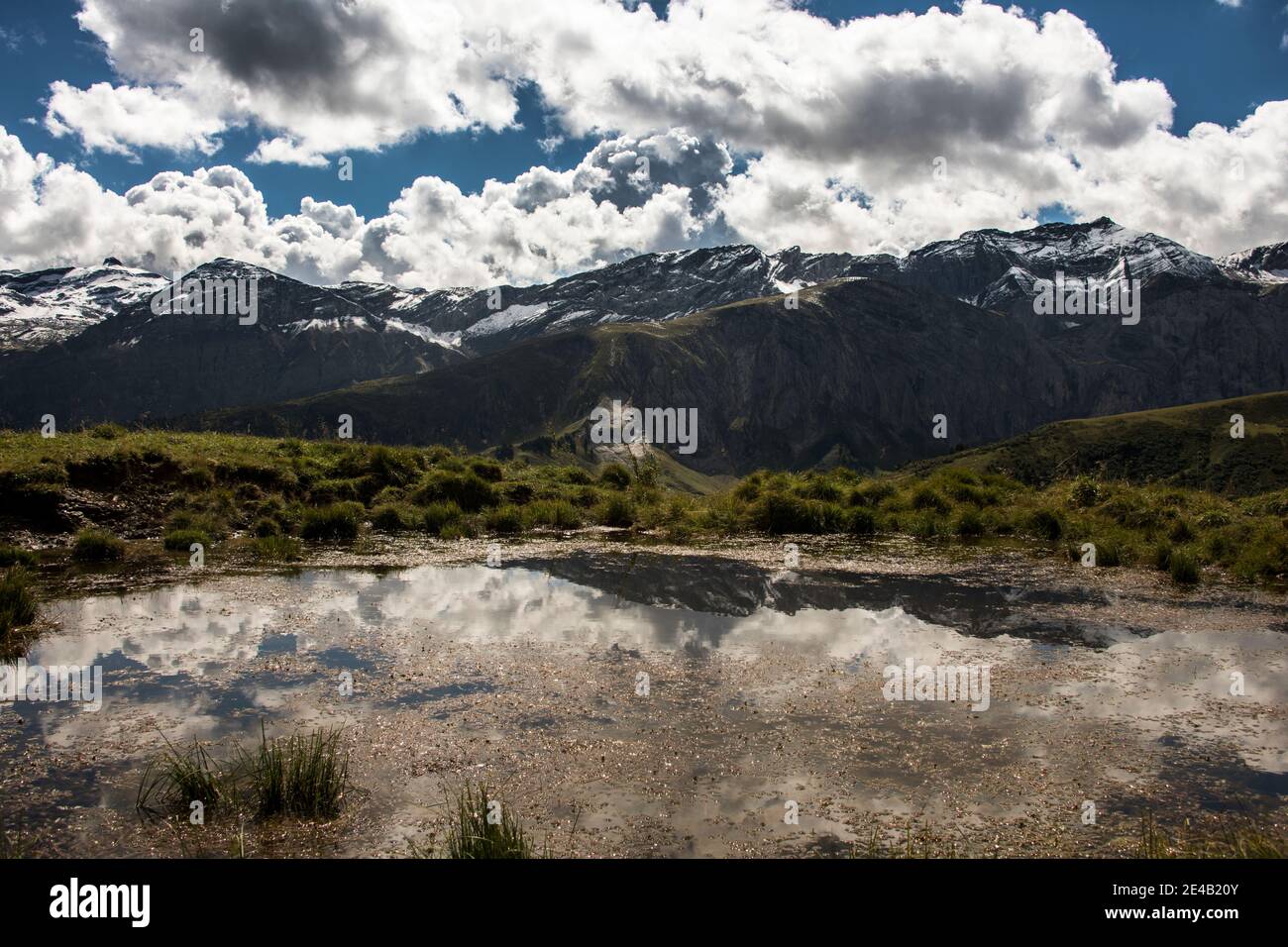 Pool with reflection, cloudy with first snow on the mountains Stock Photo