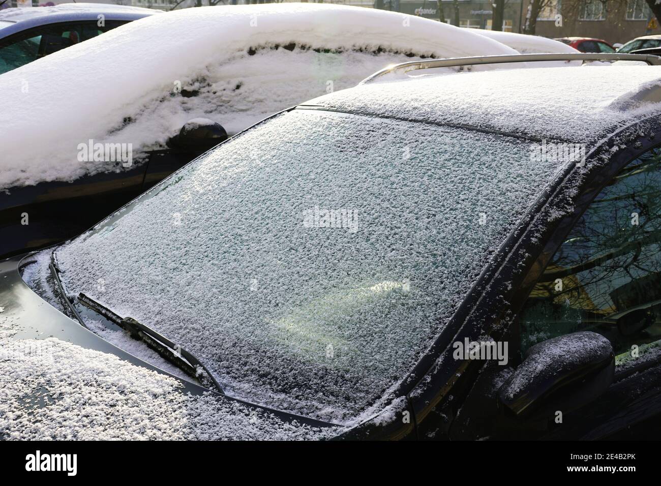 Cars covered with a thick layer of frozen snow. The estate car park in winter. Stock Photo