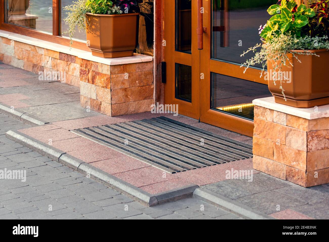 threshold with a foot mat at the front door with a stone facade and