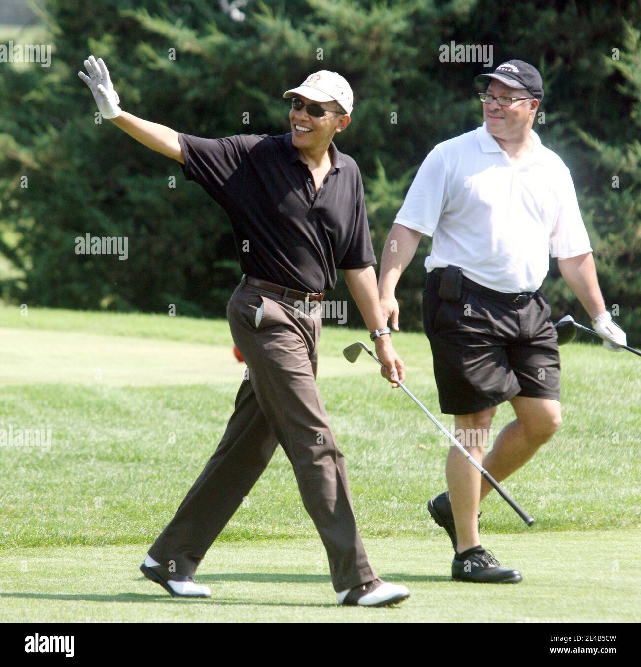 US President Barack Obama, with Dr. Eric Whitaker, a long-time friend of Chicago, waves to spectators on Farm Neck Golf Course in Oak Bluffs, Massachussetts, USA on August 24, 2009, during a round of golf. The President's tee shot landed in the woods. The other players in the foursome were Marvin Nicholson, White House trip director, and Robert Wolf, CEO of UBS. Pool photo by Vincent DeWitt/ABACAPRESS.COM Stock Photo