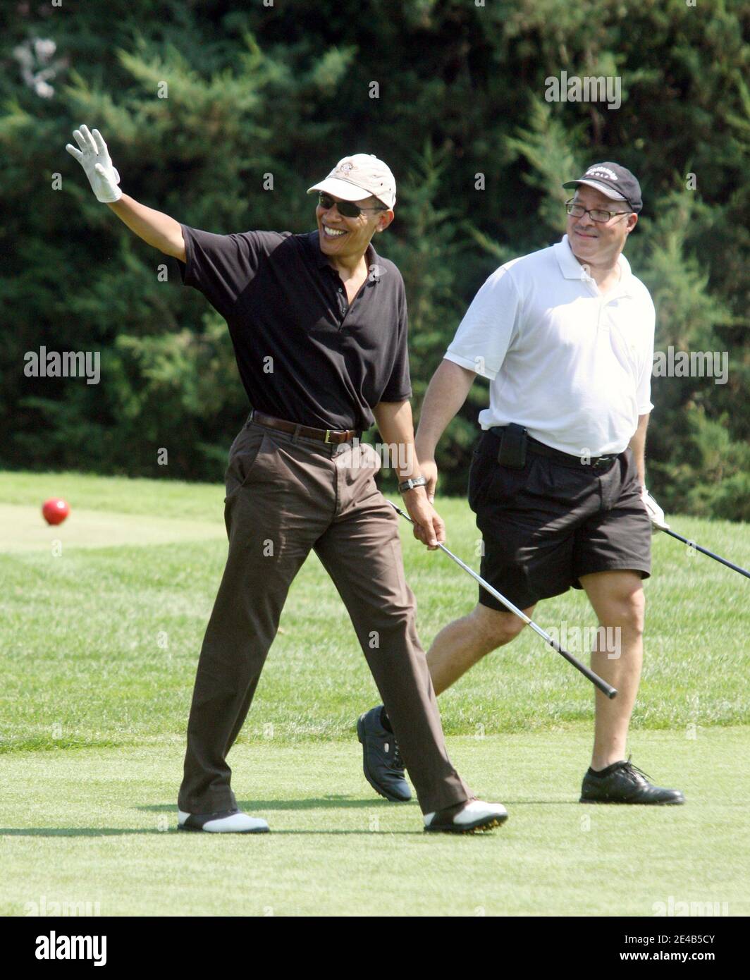US President Barack Obama, with Dr. Eric Whitaker, a long-time friend of Chicago, waves to spectators on Farm Neck Golf Course in Oak Bluffs, Massachussetts, USA on August 24, 2009, during a round of golf. The President's tee shot landed in the woods. The other players in the foursome were Marvin Nicholson, White House trip director, and Robert Wolf, CEO of UBS. Pool photo by Vincent DeWitt/ABACAPRESS.COM Stock Photo