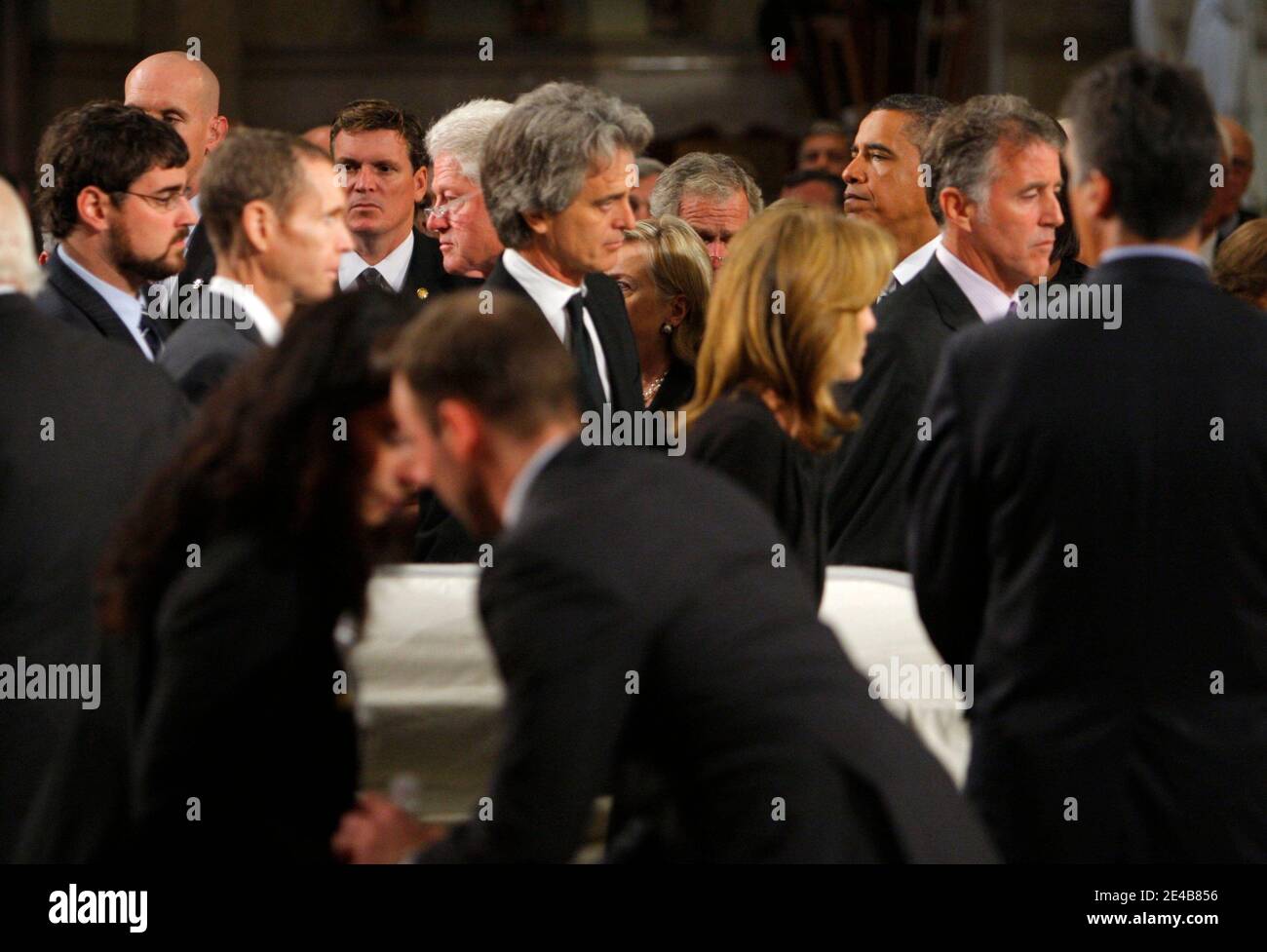 Pallbearers from the Kennedy including (L-R), his stepson Curran Raclin (with beard), his brother in law Ed Michael Reggie, his nephew Bobby Shriver, his niece Caroline Kennedy, and his nephew Christopher Lawford carry Senator Edward Kennedy's white draped casket past former President Bill Clinton and President Barack Obama (Rear) during. during funeral services for U.S. Senator Edward Kennedy at the Basilica of Our Lady of Perpetual Help in Boston, MA, USA, on August 29, 2009. Senator Kennedy died late Tuesday after a battle with cancer. Pool photo by Brian Snyder/ABACAPRESS.COM (Pictured: Bi Stock Photo