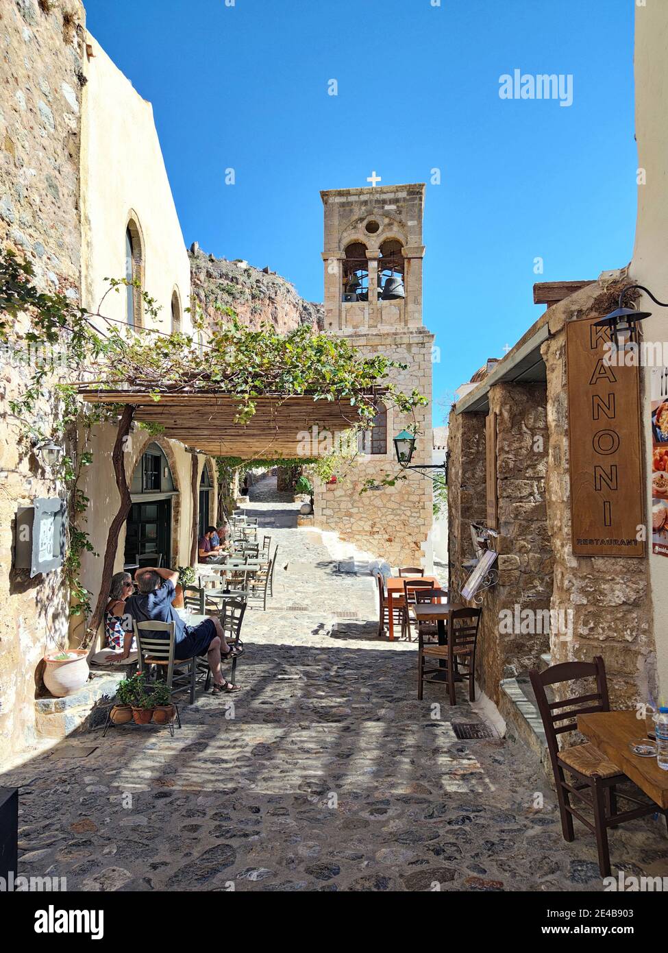 A narrow alley leads to a free-standing bell tower in the lower town of Monemvasia, Corona times, Laconia, Peloponnese, Greece Stock Photo