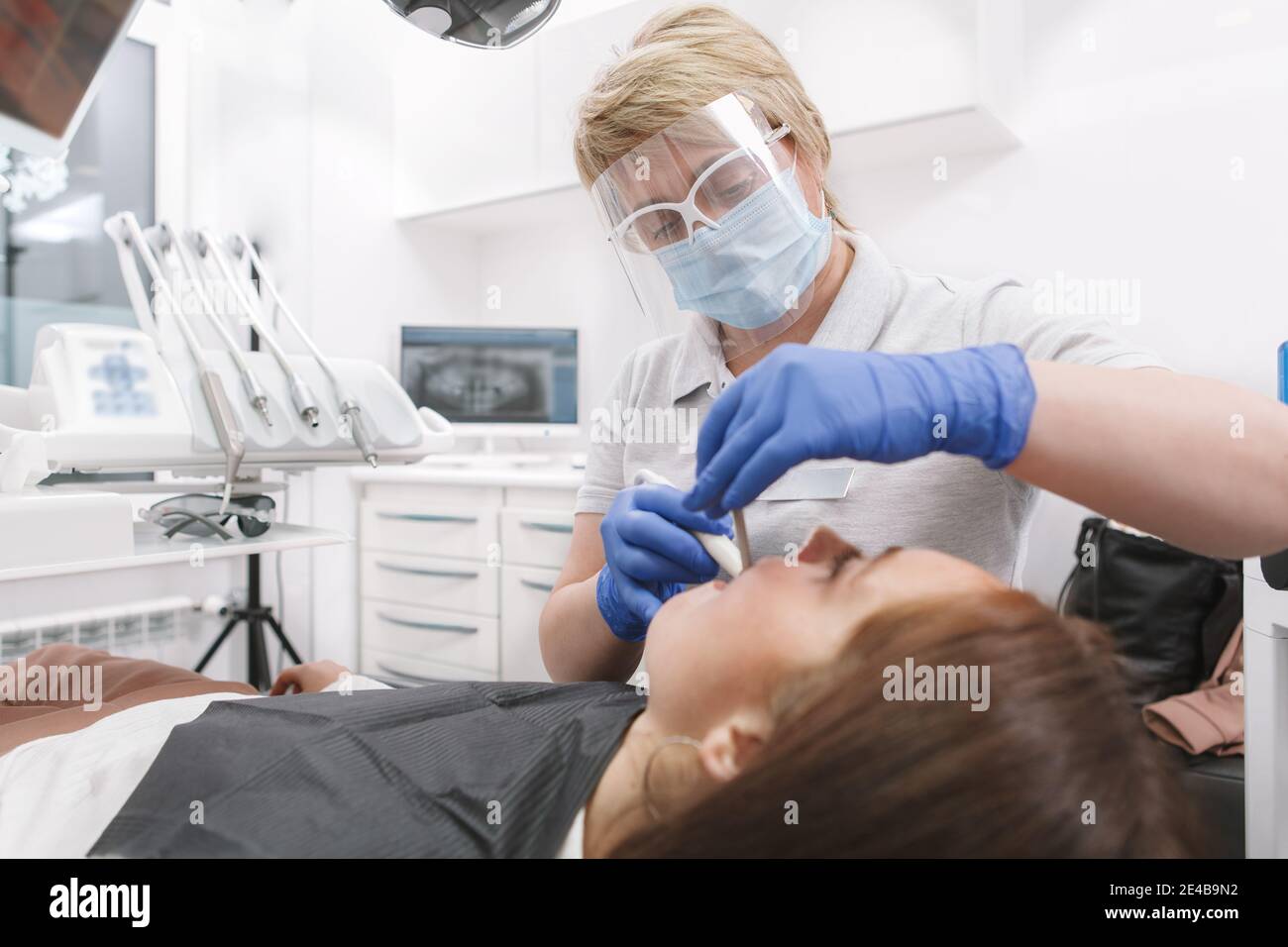 Professional dentist wearing medical face mask, working at her clinic during coronavirus