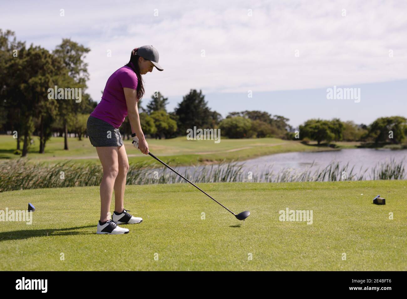 Caucasian woman playing golf swinging club and taking a shot Stock Photo