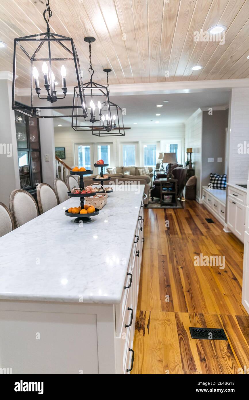 Large renovated white kitchen with textured subway tile, black iron