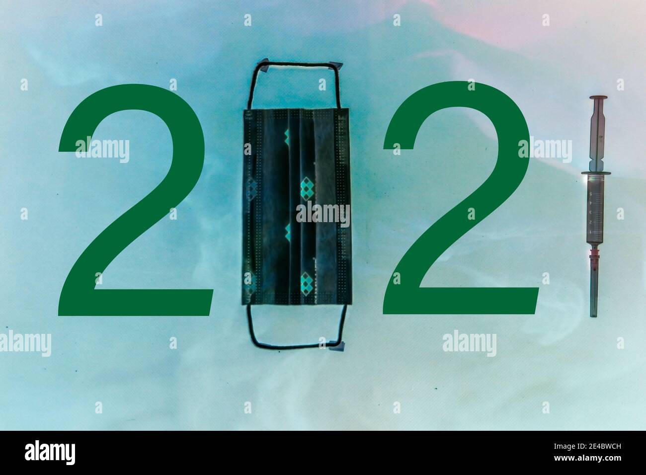 The number 2021 written with mask, number and syringe. A design considered due to Covid-19. Different symbols in the background. 2021 year themed. Stock Photo