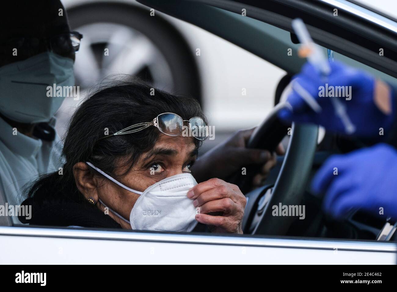 Los Angeles, California, USA. 22nd Jan, 2021. A passenger looks on as a healthcare worker holds a coronavirus vaccine needle in a parking lot at the Pomona Fairplex. Credit: Ringo Chiu/ZUMA Wire/Alamy Live News Stock Photo