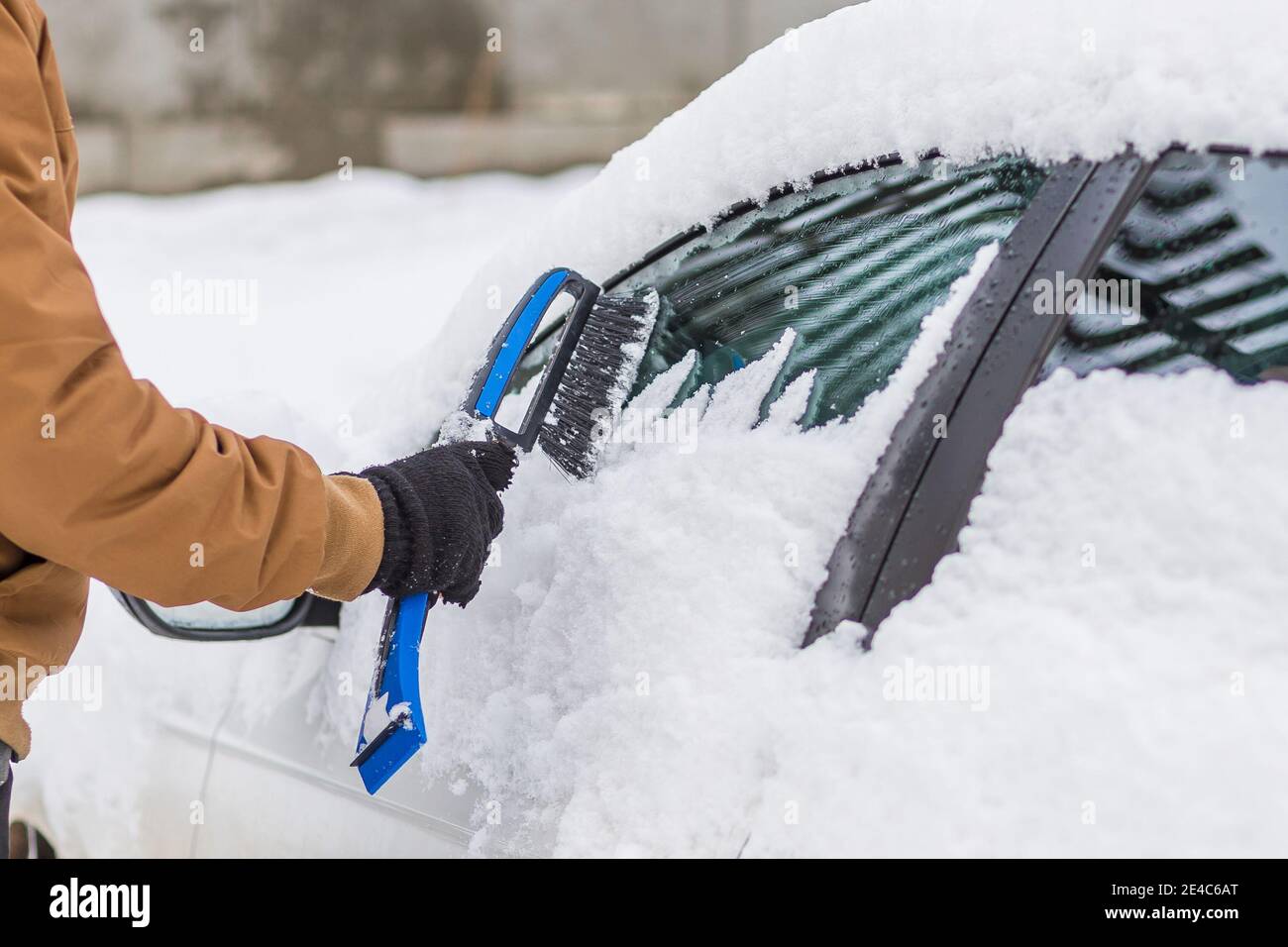 Man clear snow from car with cleaning tool Stock Photo Alamy