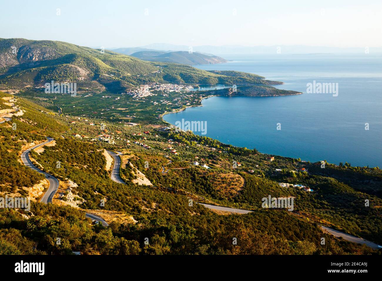 Blick aus der Berglandschaft auf die kurvenreiche Bergstraße und die Bucht von Palea Epidauros Epidauros, Argolis, Griechenland Stock Photo