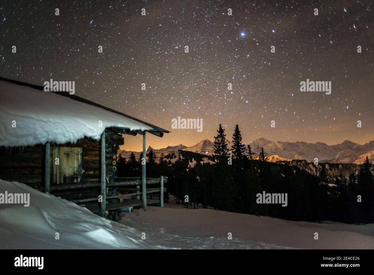 snow-covered alpine huts at night under the stars Stock Photo