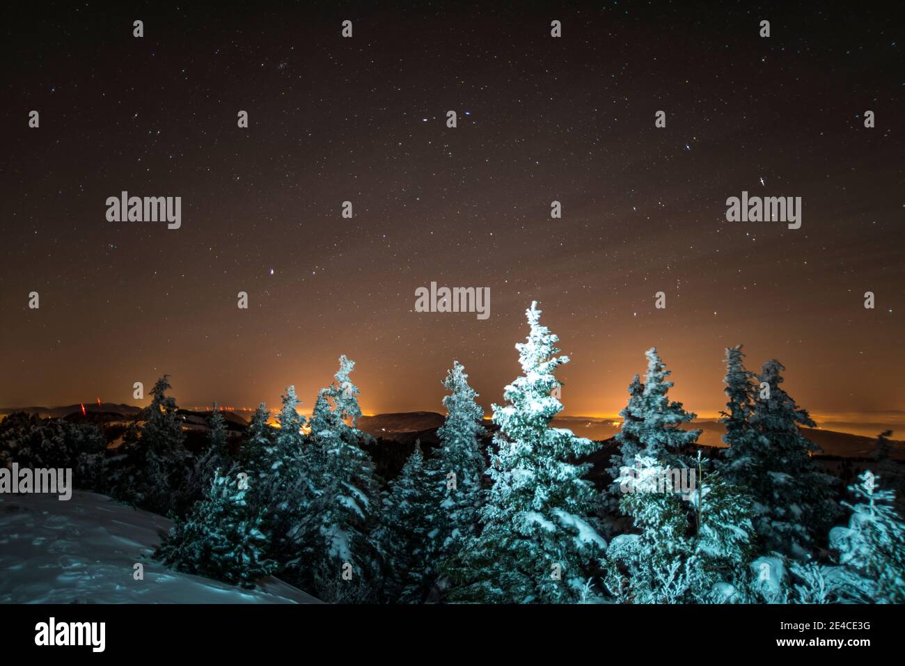 Christmassy, snowy mountain peaks under the stars Stock Photo