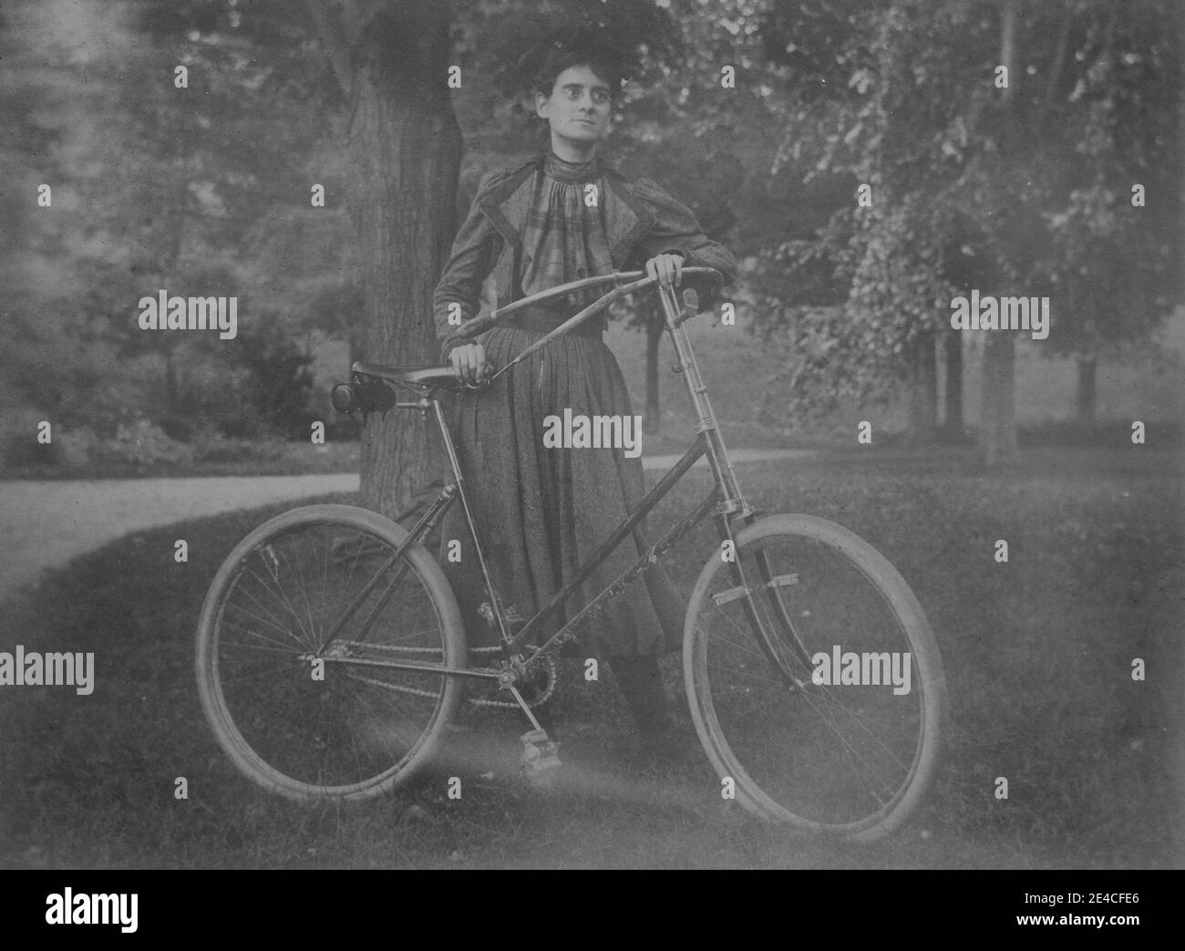 American archive monochrome portrait  of a young woman wearing cycling dress with her bicycle in USA Stock Photo
